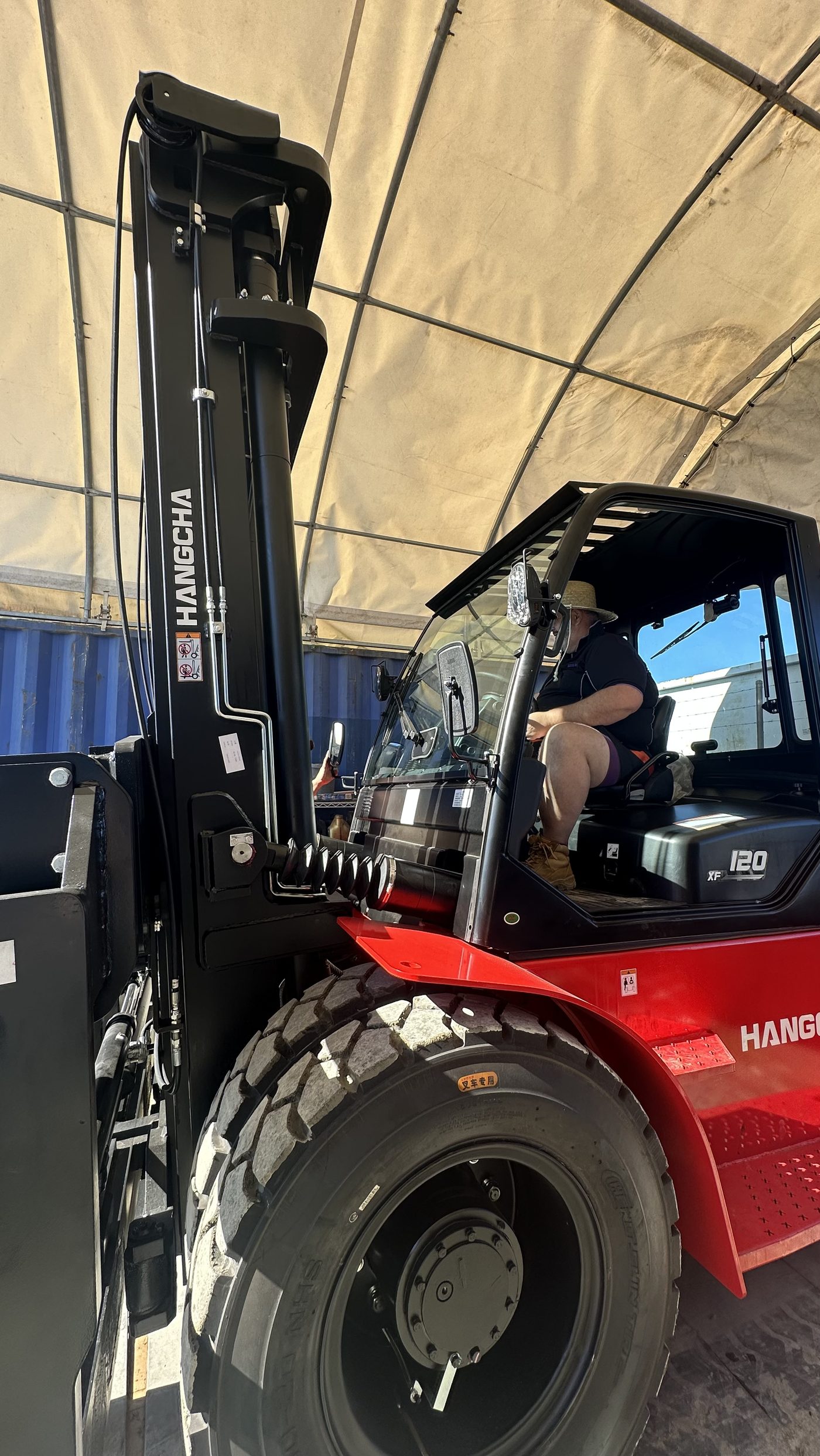 Forklift handling a Jacaranda storage container under cover